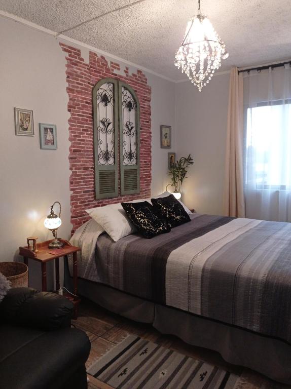 um quarto com uma cama e uma parede de tijolos em Dulce hogar em Santiago