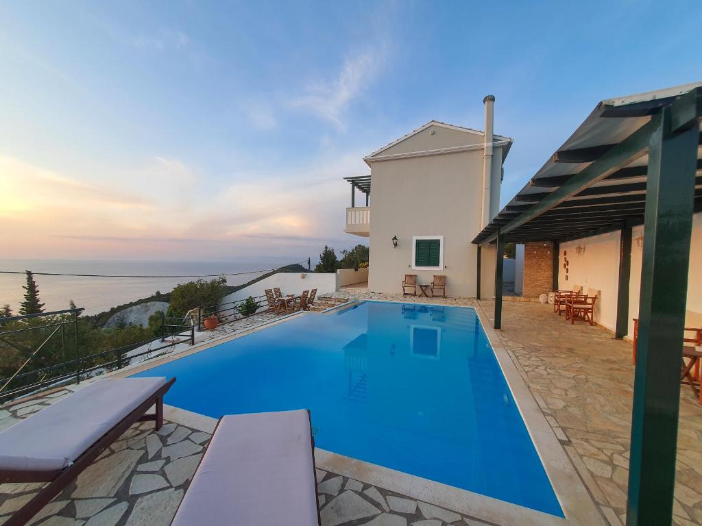 a swimming pool with a view of the ocean at Villa Ioanna in Kalamitsi