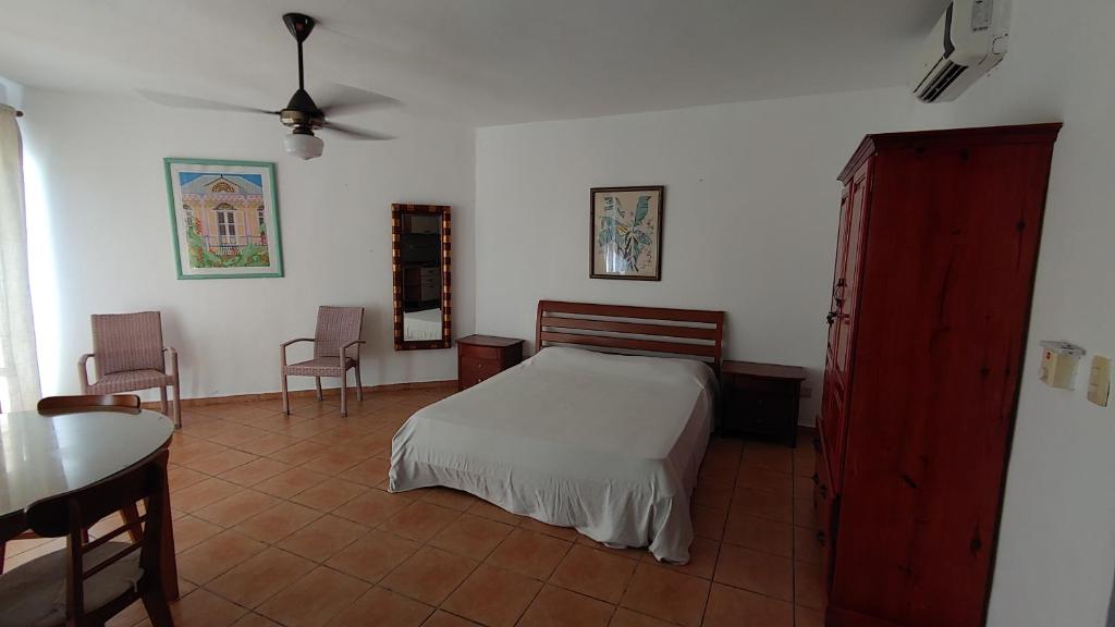 1 dormitorio con 1 cama, mesa y sillas en Estudio Albatros By Meridiana, en Juan Dolio