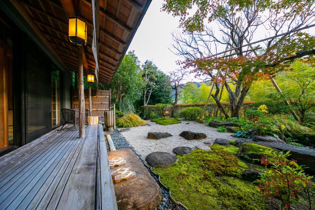 um quintal com um deque de madeira e um jardim em ふきや旅館 Fukiya Ryokan em Yugawara