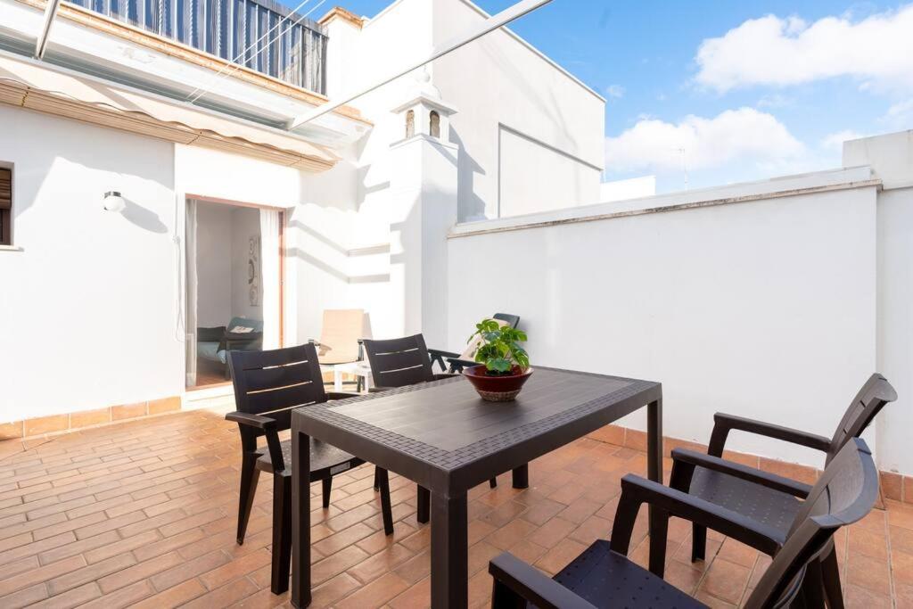 d'un patio avec une table noire et des chaises sur une terrasse. dans l'établissement Cómodo apartamento en Almonte, à Almonte