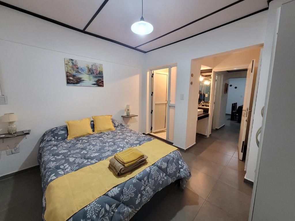 - une chambre dotée d'un lit avec une couverture bleue et jaune dans l'établissement Departamento Mis Nonos 2, à Mendoza
