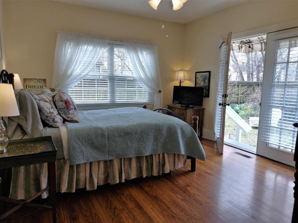 a bedroom with a bed and a large window at Urban Cottages in Little Rock