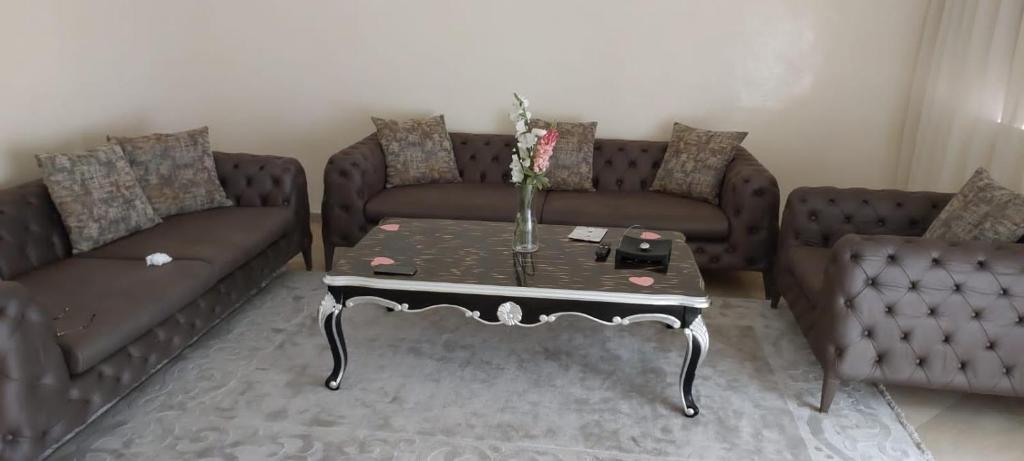 uma sala de estar com dois sofás e uma mesa de centro em Apparemment près Anfa parc em Casablanca
