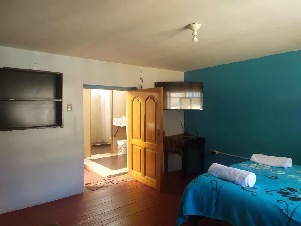 Habitación azul con cama y puerta en mini-hogar en santa teresa, en Santa Teresa
