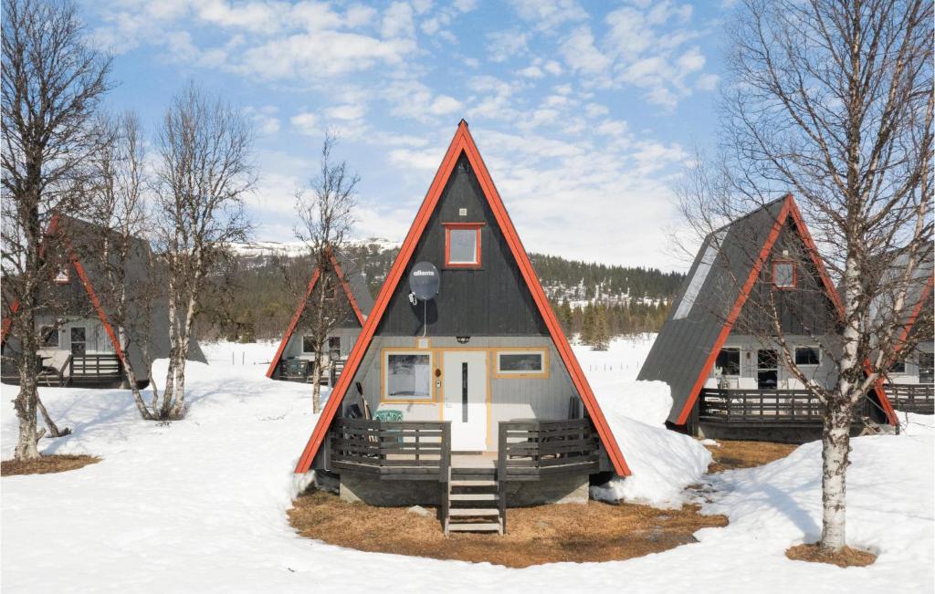 una casa con techo triangular en la nieve en Lovely Home In Heggenes With House A Mountain View, en Heggenes