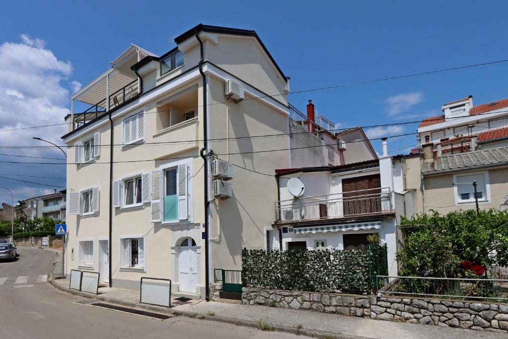 un bâtiment blanc sur le côté d'une rue dans l'établissement Apartments by the sea Selce, Crikvenica - 18195, à Selce