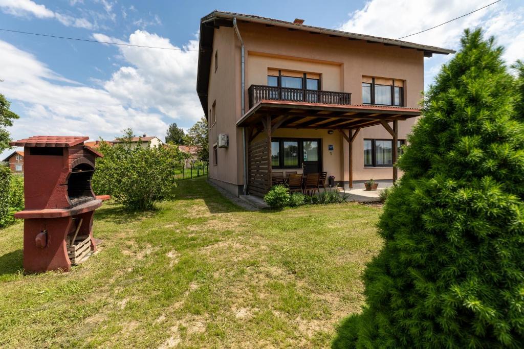 a house with a tree in the yard at Apartments for families with children Karlovac - 20989 in Karlovac