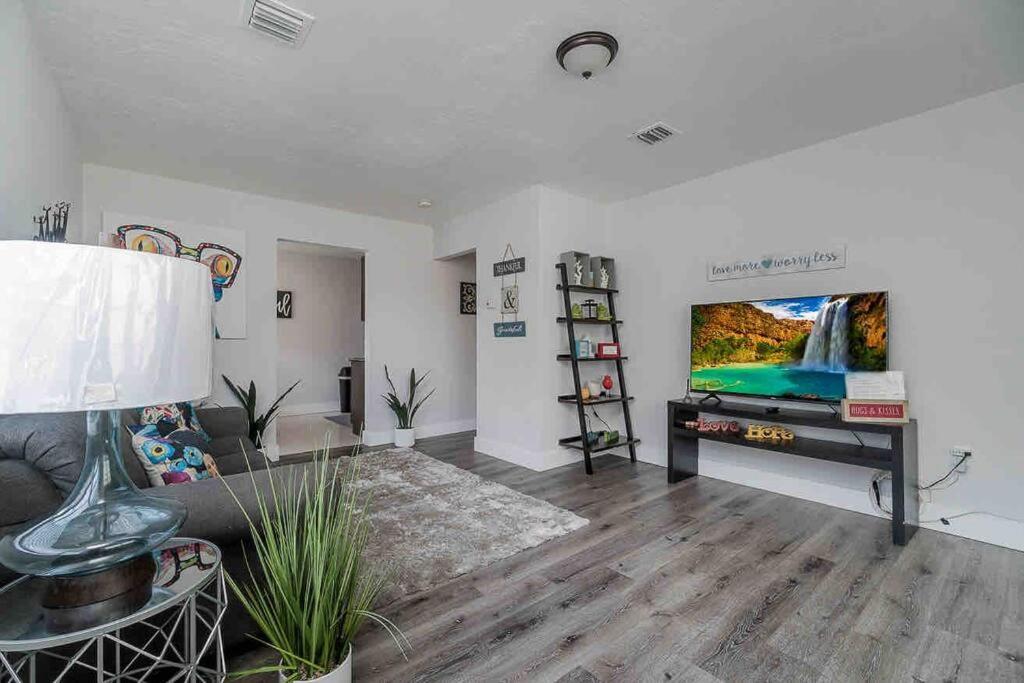 een woonkamer met een bank en een flatscreen-tv bij PARADISE II MIAMI BEACH HOUSE in Miami