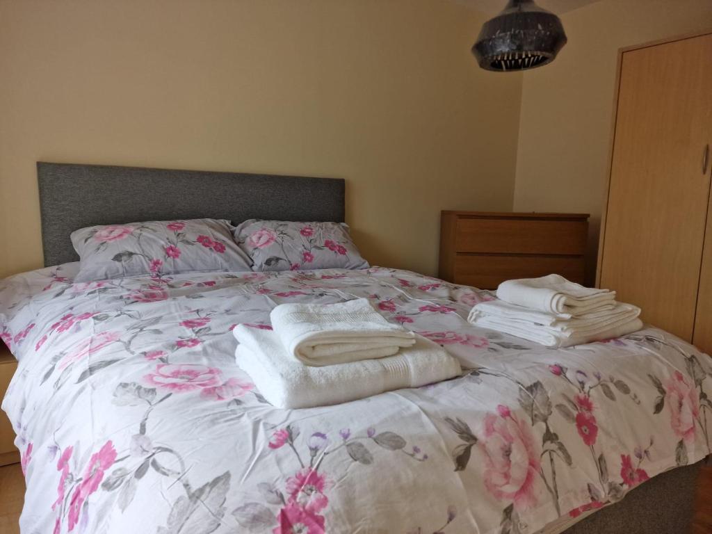 Una cama con toallas apiladas encima. en Clearwater Apartment, en Dublín