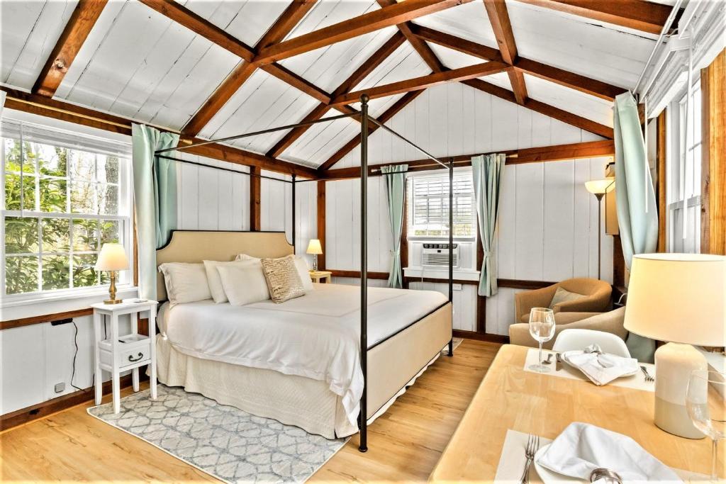 1 dormitorio con 1 cama en una habitación con techos de madera en The Seagrove Suites & Guest Rooms, en Eastham