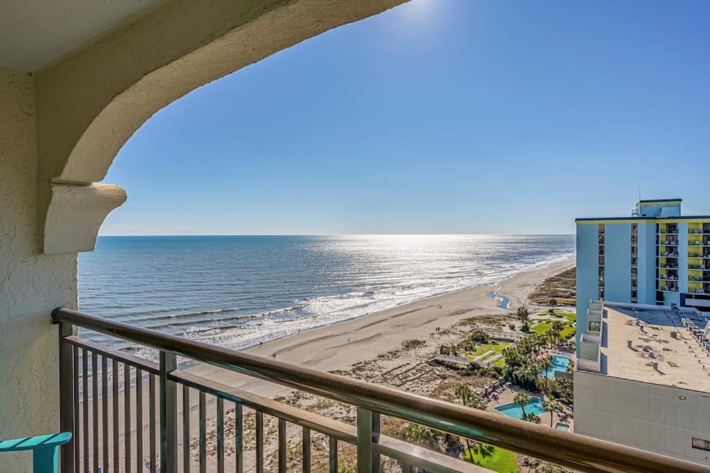 a balcony with a view of the beach and a building at Caravelle Resort in Myrtle Beach