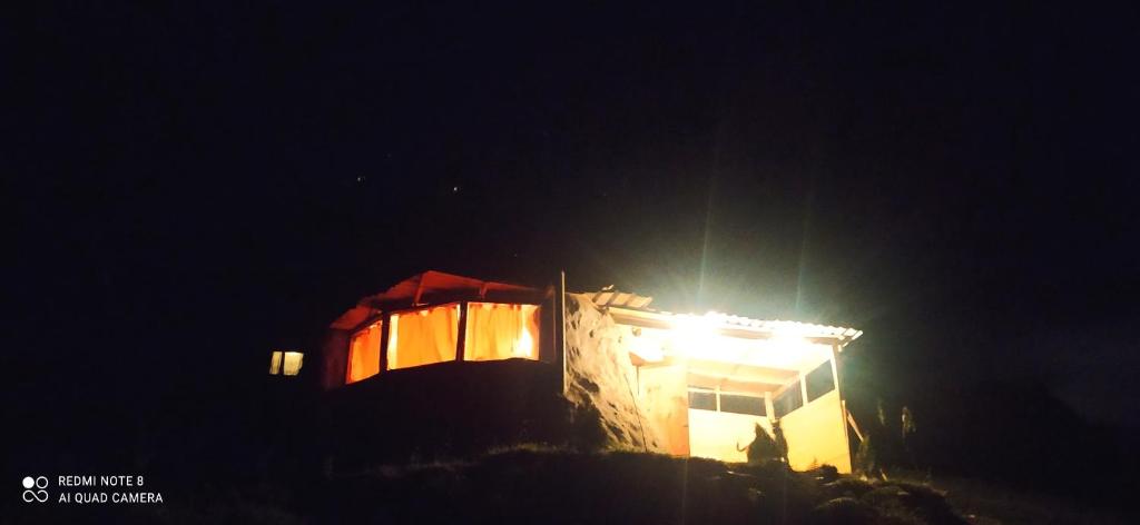 un bâtiment avec une lumière au-dessus de celui-ci la nuit dans l'établissement casa de los picapiedra, à Sesquilé