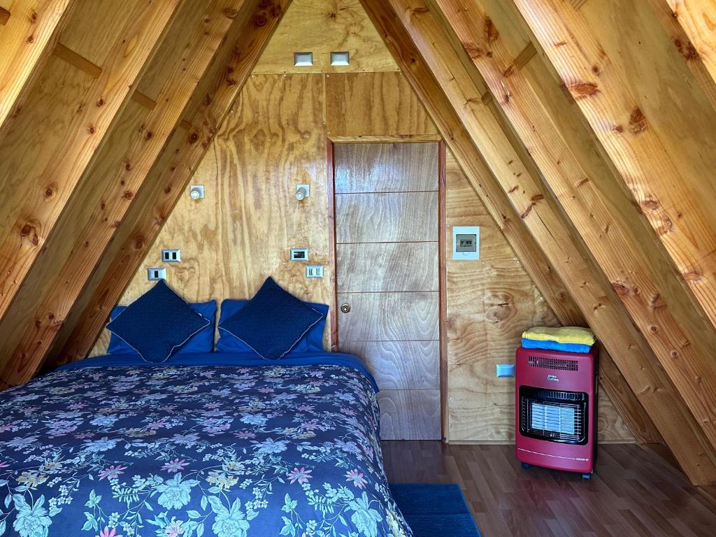 1 dormitorio con 1 cama en una cabaña de madera en A-FRAME CABIN PUCON, en Pucón