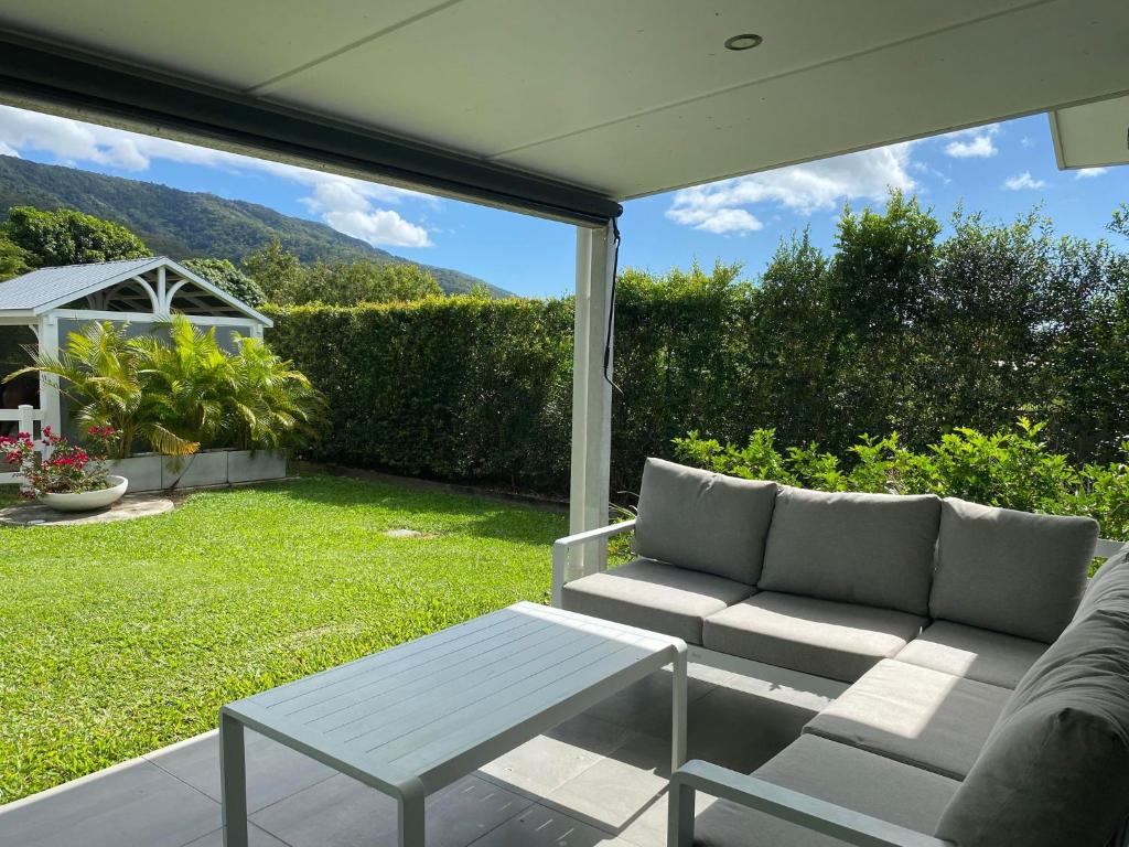 a patio with a couch and a table in a yard at Ranch Retreat in Kewarra Beach