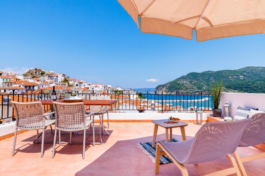 a patio with chairs and tables on a balcony at Swift View in Skopelos Town