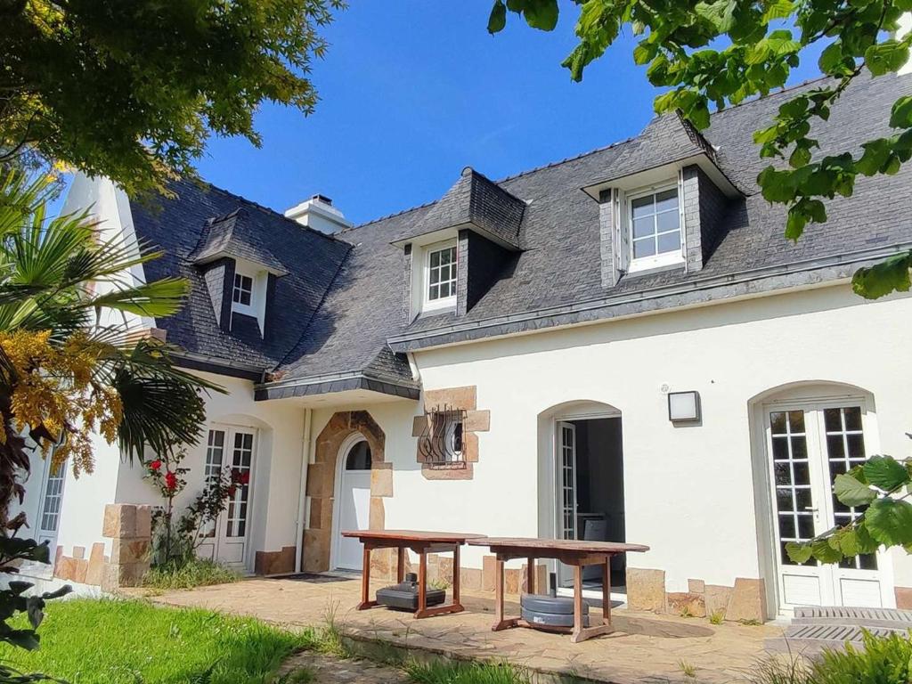 une maison avec une table de pique-nique devant elle dans l'établissement Grande Maison Familiale à Trégastel avec Jardin Clos, Terrasse et WIFI - FR-1-368-393, à Trégastel