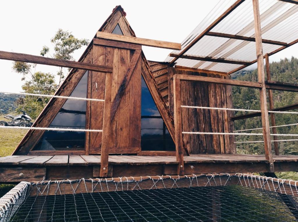 a timber frame house with a gambrel roof at La Bella Finca Hostal-Lodge in Villamaría