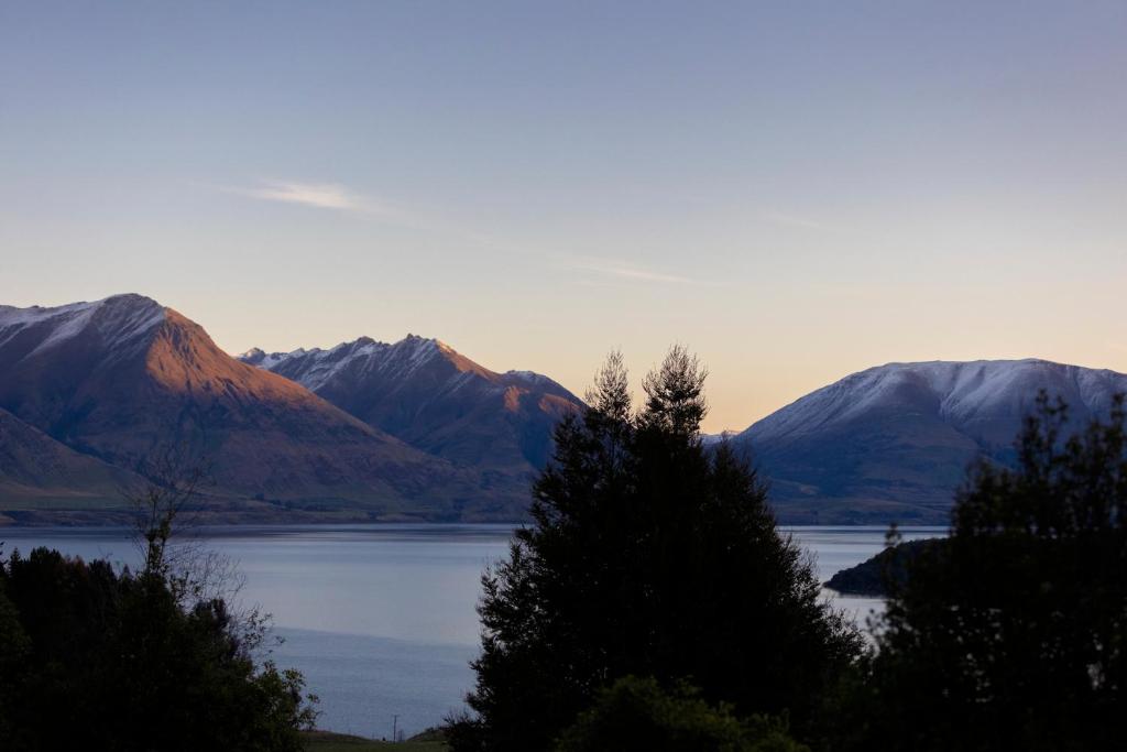 vistas a un lago con montañas en el fondo en Kereru Cottage, Romantic & Beautiful Log Cabin - Queenstown en Queenstown