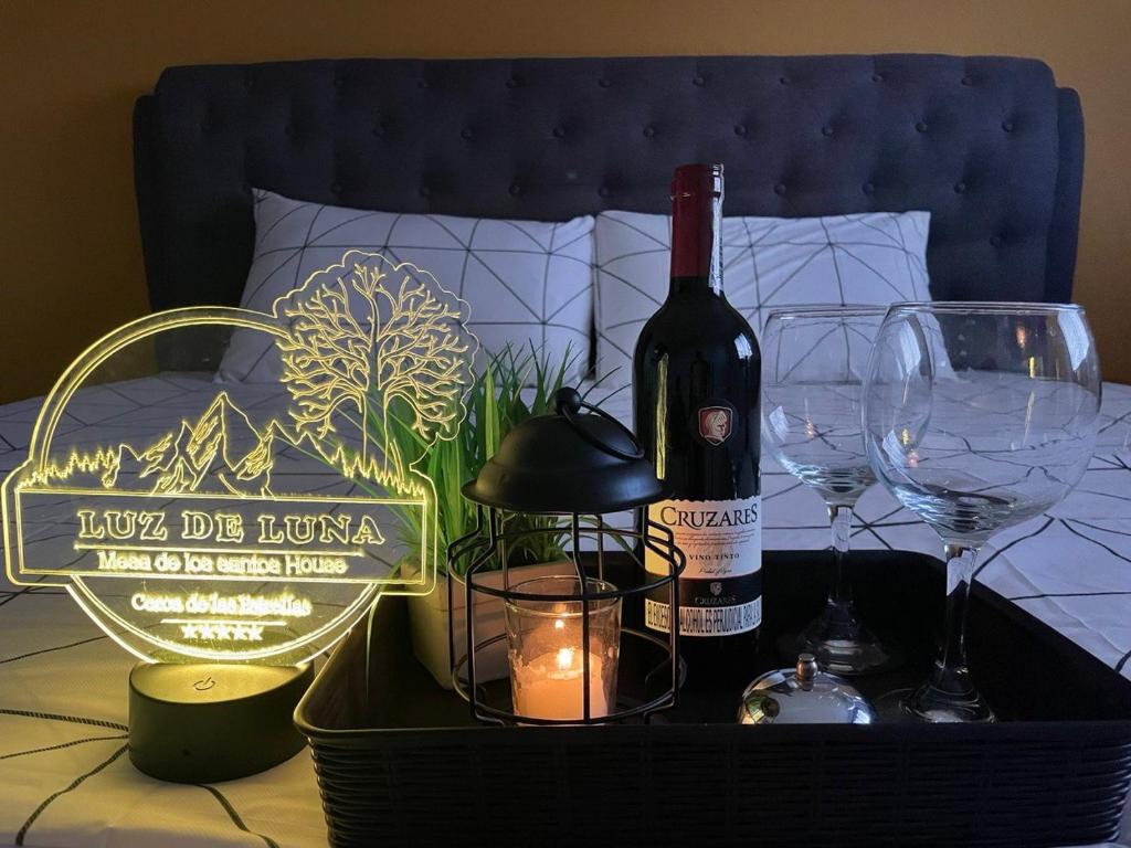 ロス・サントスにあるLUZ DE LUNA minihouseのベッドの上にワイン1本とワイングラスを用意しています。