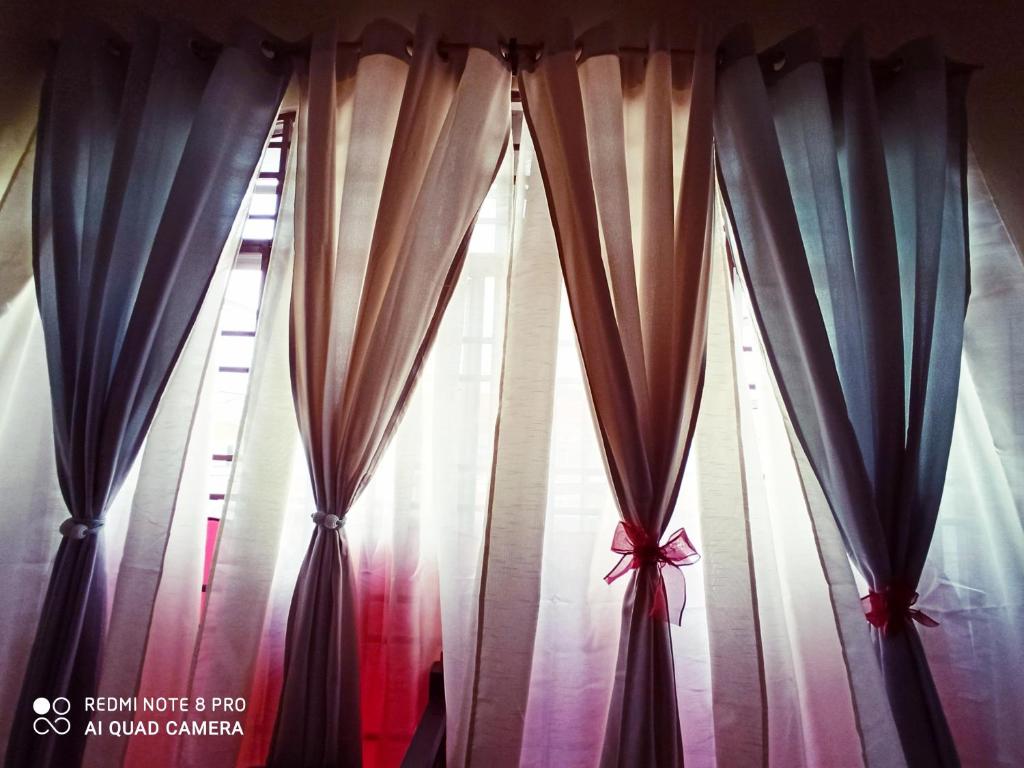 a group of curtains in front of a window at New Garden View GF Double Room FREE parking in Batu Unjor