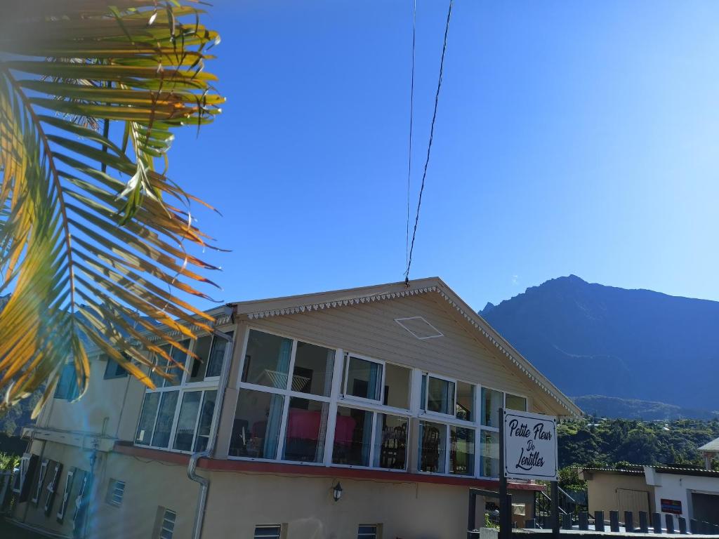 un edificio con una montaña en el fondo en Petite fleur de lentilles, en Cilaos