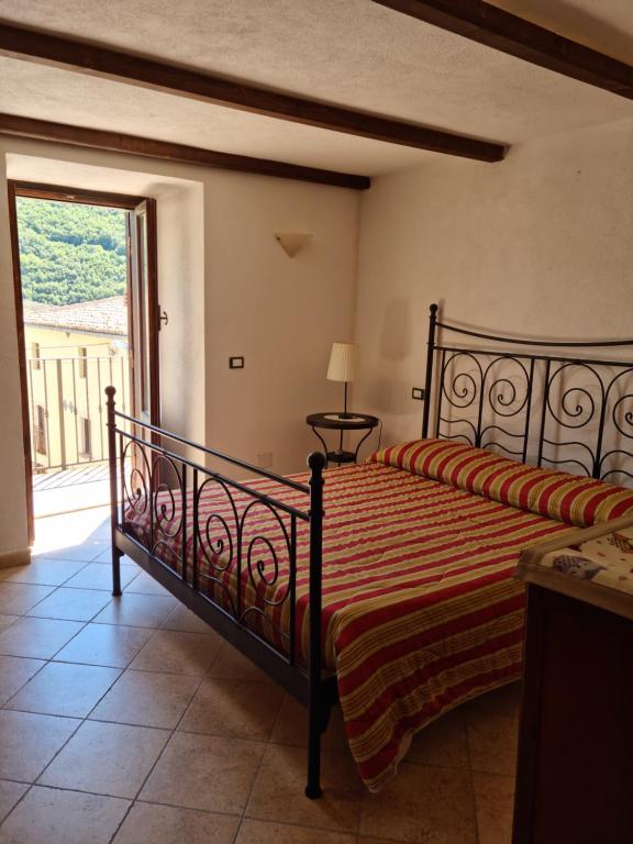 a bedroom with a bed and a large window at Il Rifugio sul Colle - Casa vacanze a Campo Felice in Casamaina