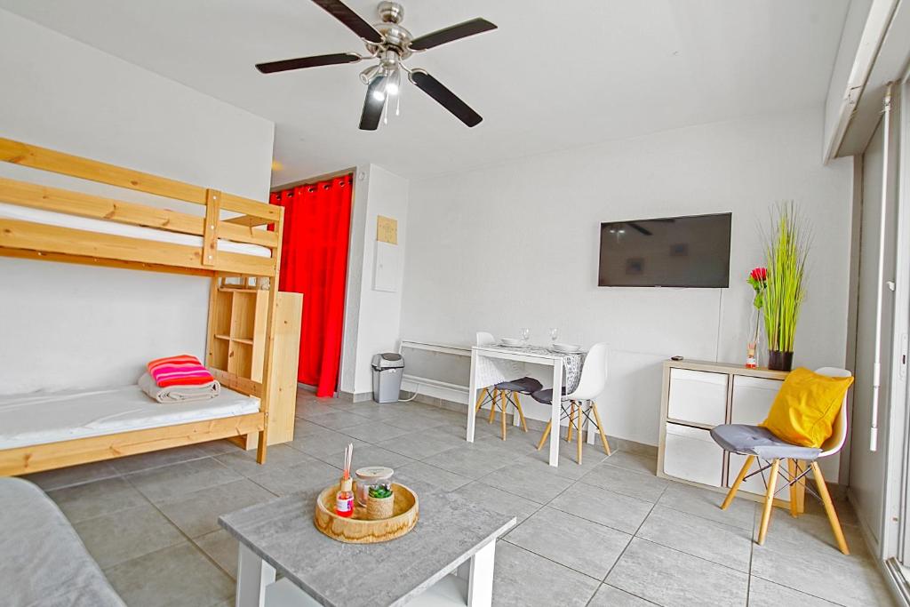 - une chambre avec des lits superposés et un bureau avec une table dans l'établissement Studio moderne avec parking et piscine- 313, à Canet