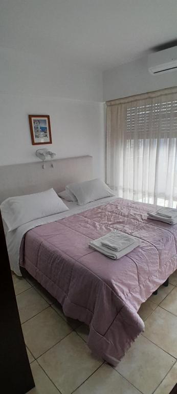 1 dormitorio con 1 cama grande con manta morada en Súper Luminoso en Caballito en Buenos Aires