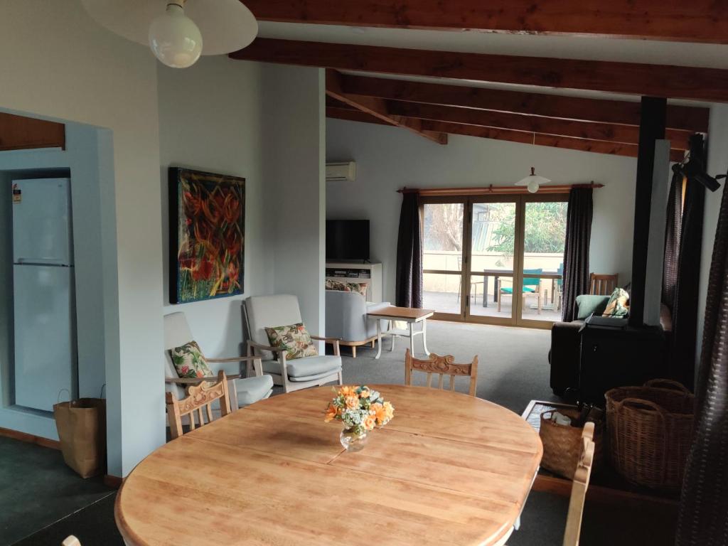 salon z drewnianym stołem z kwiatami w obiekcie Large, Comfy, Stylish Apartment w mieście Havelock North