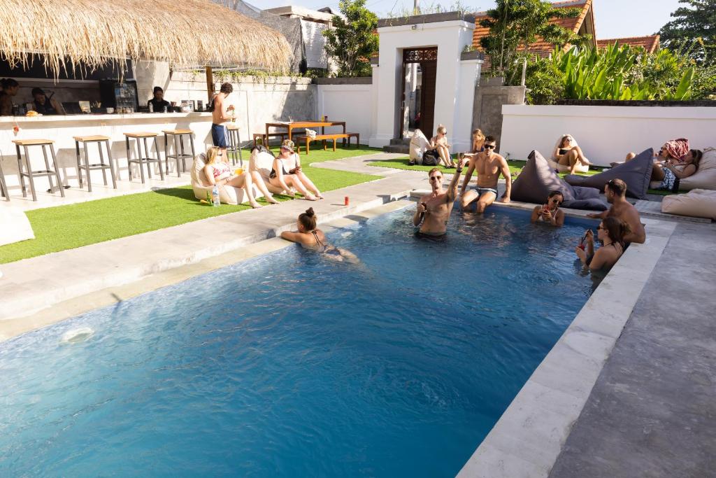 a group of people sitting in a swimming pool at Zentiga Surf Hostel in Canggu