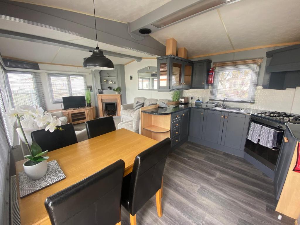 a kitchen and dining room with a wooden table at Golden Palm - Sherwood 472 - S472 in Skegness