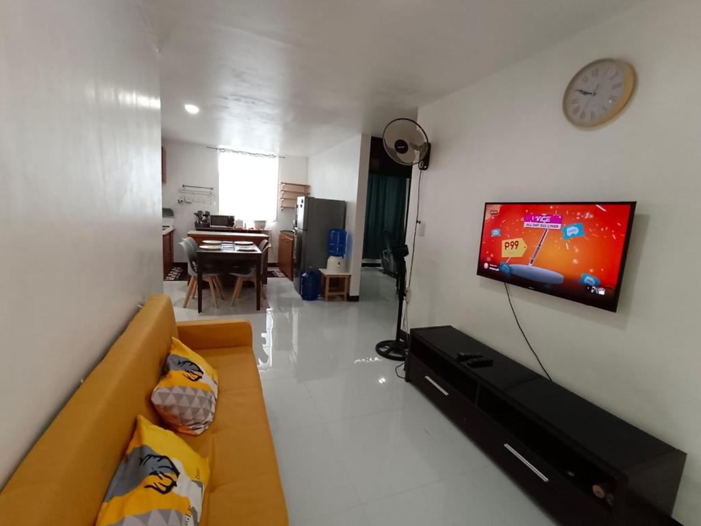 uma sala de estar com um sofá e uma televisão na parede em Three-Bedroom Holiday Home - 4th Floor Stairs Only em Mactan
