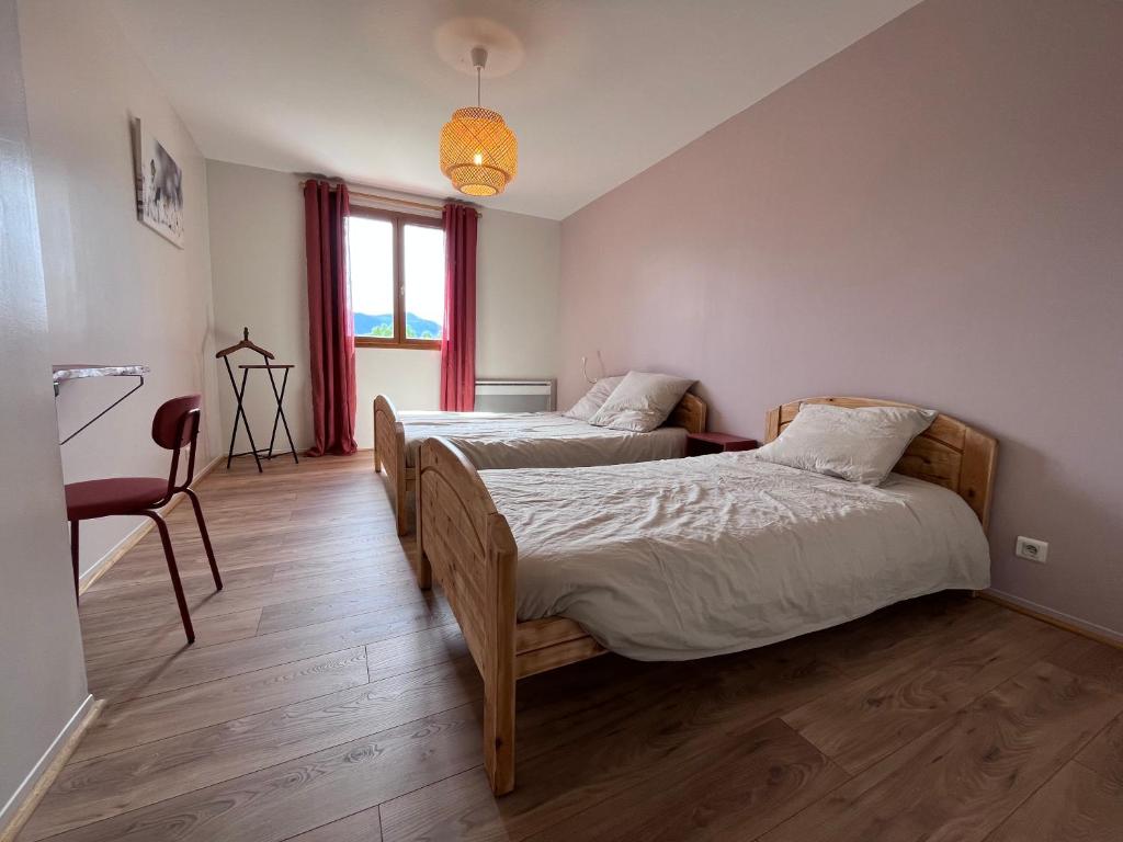 um quarto com 2 camas, uma cadeira e uma janela em Auberge de Sauze em Sauze