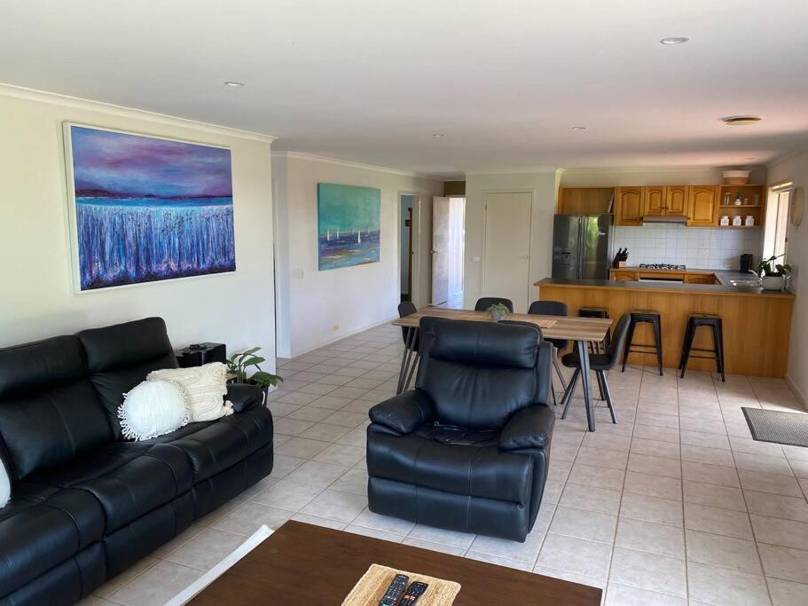 a living room with a couch and a table at Open 4 bedroom home in Warrnambool