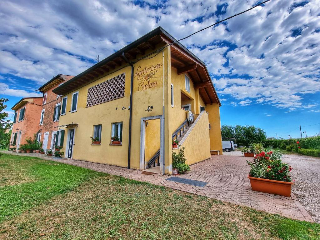 un edificio amarillo con una puerta a un lado en Agriturismo Ceolara, en Sommacampagna