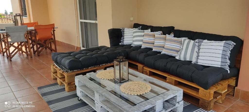 a living room with a black couch with pillows on it at Sofia's pottery house in Volos