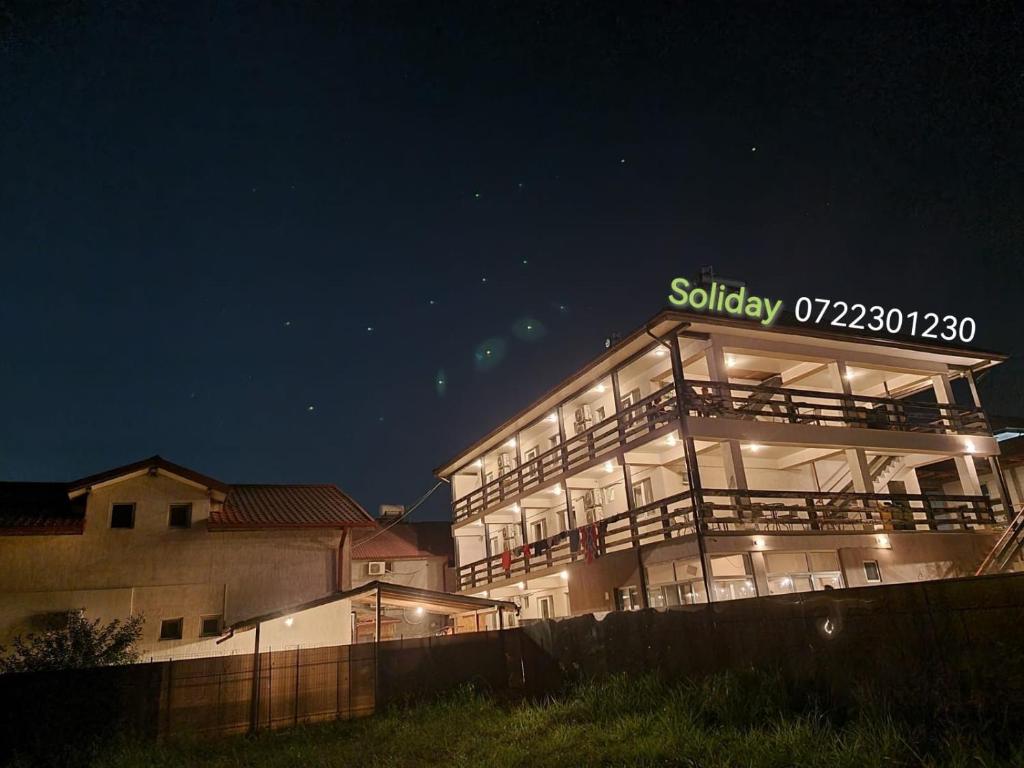 ヴァマ・ヴェケにあるSolidayの夜間の看板のある建物