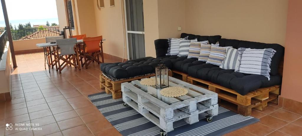 a living room with a black couch and a table at Sofia's pottery house in Volos