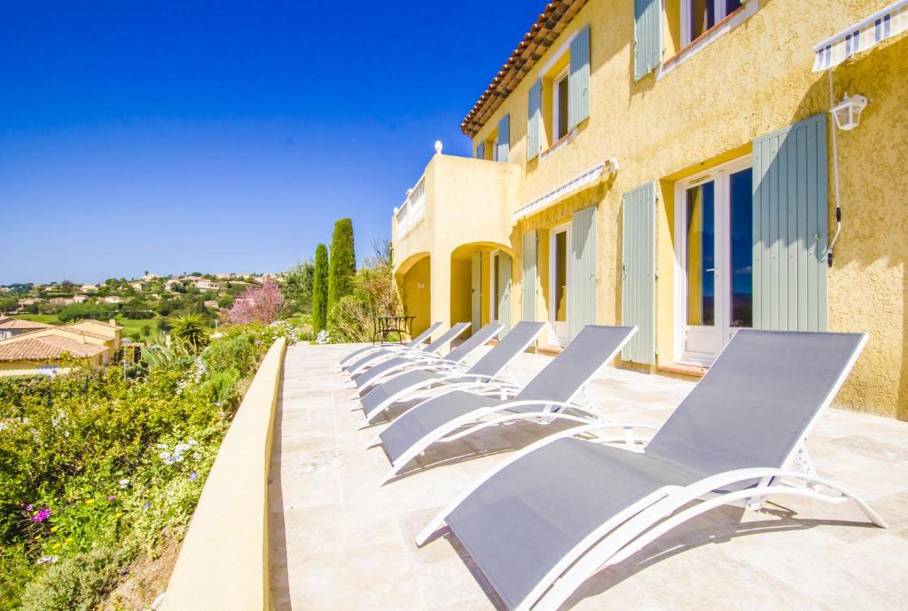 a row of lounge chairs sitting outside of a building at Grande Villa à Sainte Maxime - Golfe de Saint Tropez in Sainte-Maxime
