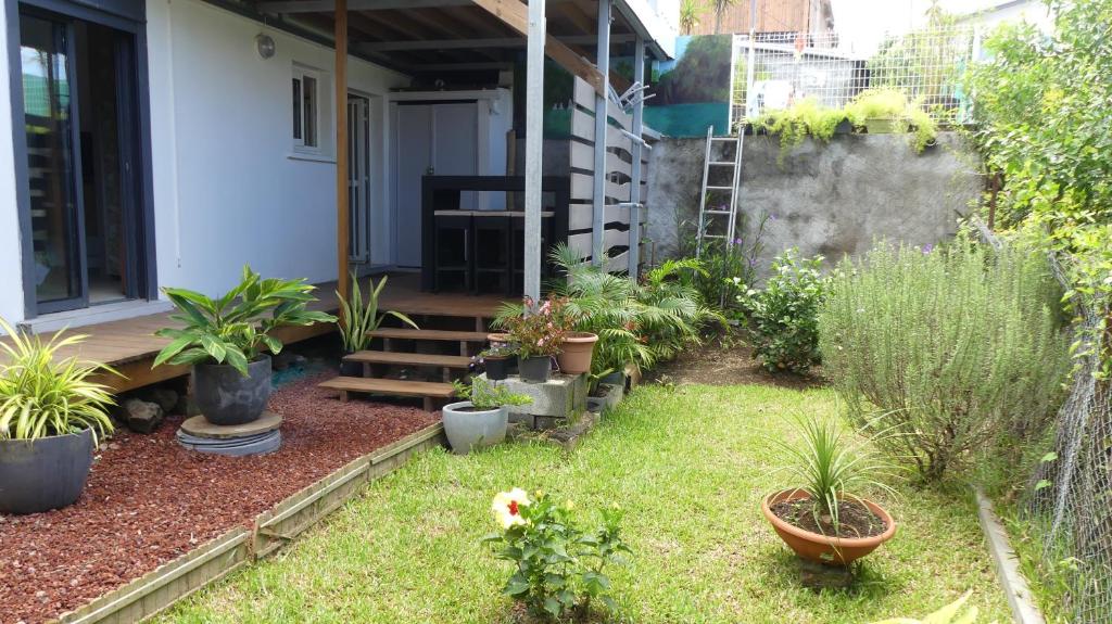 un jardin avec des plantes en pot sur une maison dans l'établissement KAZ à LILO, à Petite Île