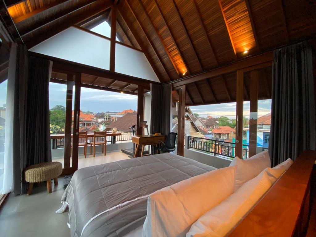 um quarto com uma cama grande e uma varanda em Dewa Hostel em Ubud