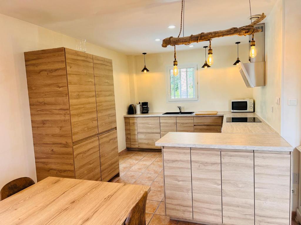 a kitchen with wooden cabinets and a wooden table at Grande Villa à Sainte Maxime - Golfe de Saint Tropez in Sainte-Maxime