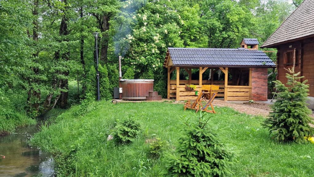 a log cabin with a gazebo next to a river at Vodenica Vrelo Chalets in Vrelo Koreničko
