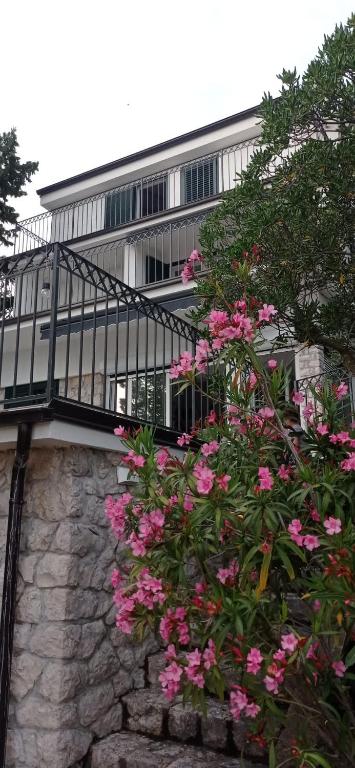 a building with a balcony and pink flowers at Adria Vista Dramalj in Dramalj