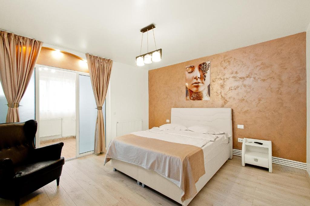 1 dormitorio con 1 cama blanca y 1 silla en Danube Residence, en Galaţi