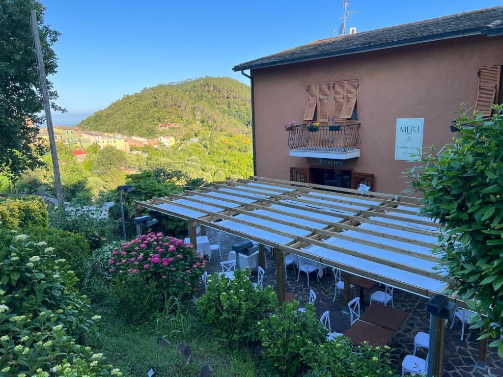 un edificio con sedie e balcone di Hotel Meri 1956 Locanda e Cucina a Framura