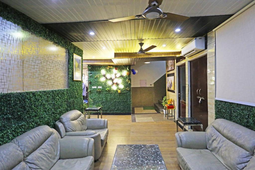 een woonkamer met banken en een groene muur bij Hotel GL Suites Near Delhi Airport in New Delhi