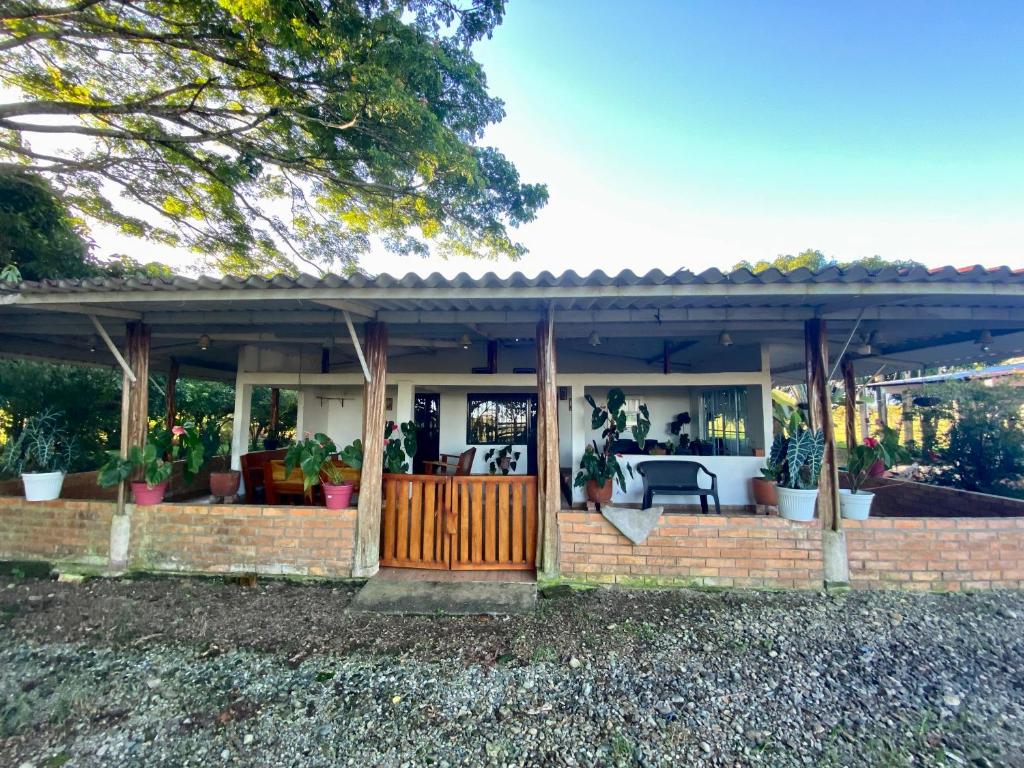 una casa con un porche con macetas. en Hacienda Veracruz, en Villagarzón