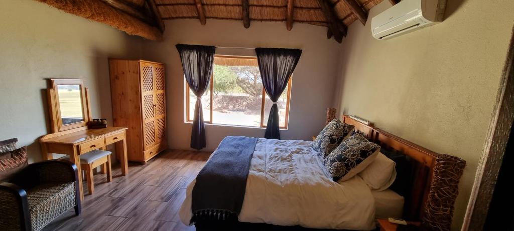 1 dormitorio con cama y ventana en Mothopo Game Lodge, en Modimolle